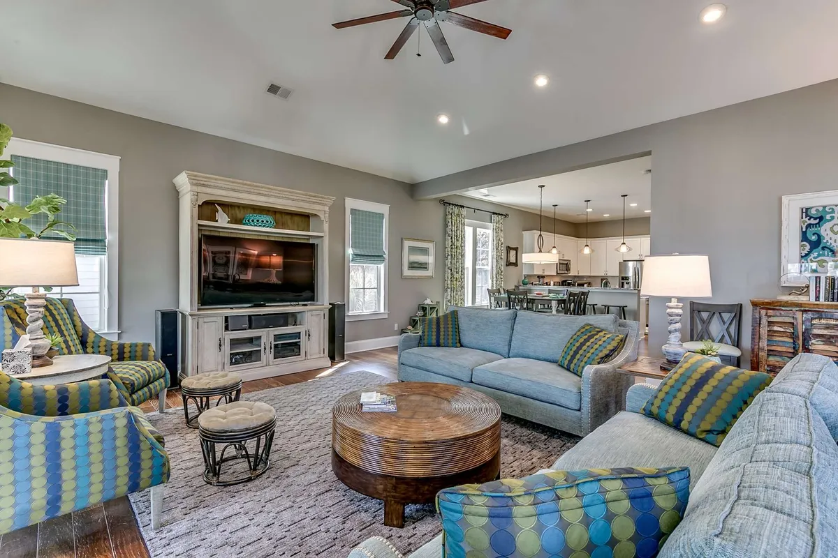 A comfortable, welcoming living room featuring a sofa, coffee table, and a television set. Cozy decor and ample seating invite guests to gather, relax, and enjoy shared activities such as movie nights or socializing.